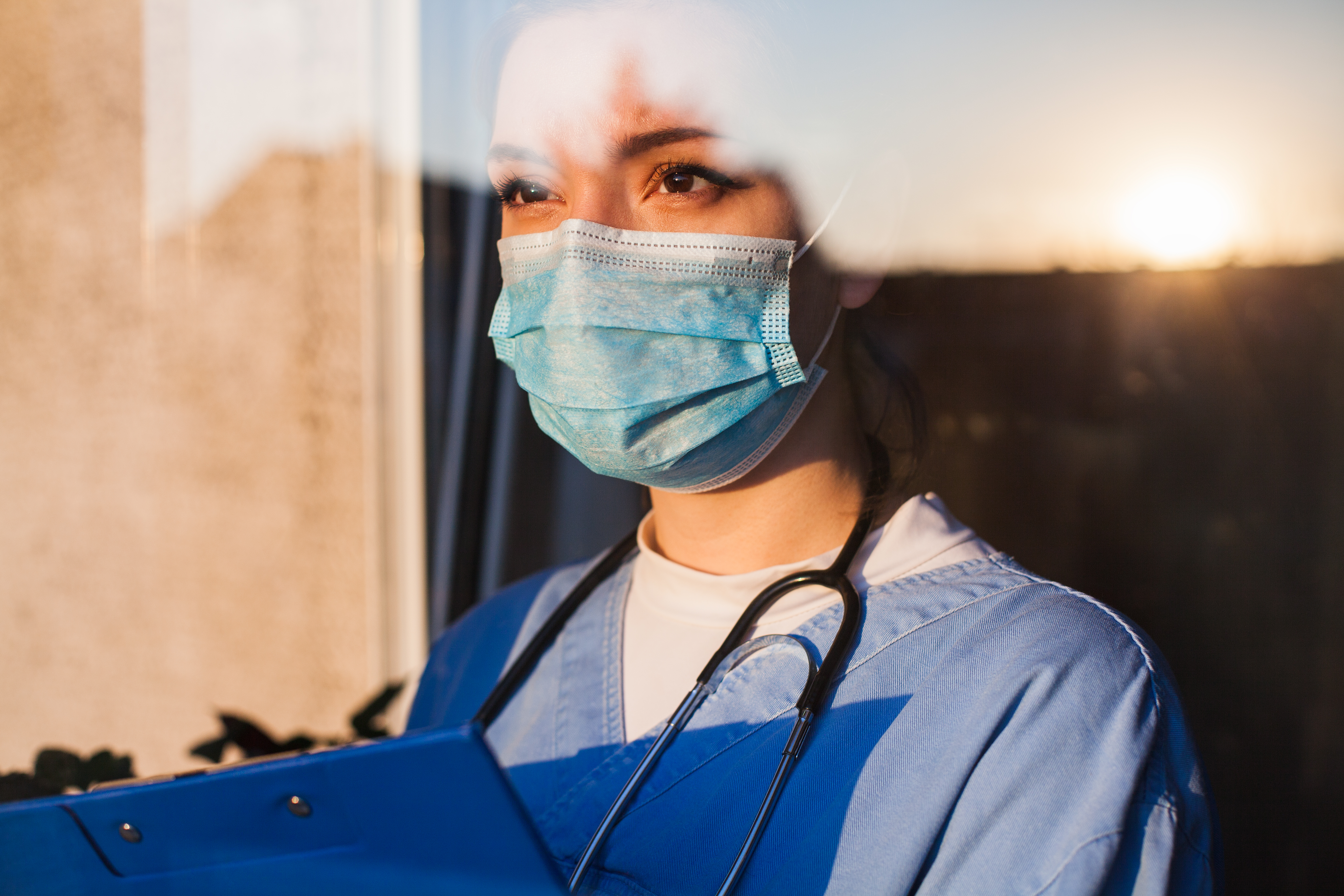 young-female-doctor-looking-through-window-2022-06-23-19-07-55-utc-1675265765.jpg